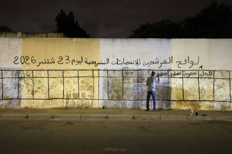 Un homme marque un mur destiné à accueillir les affiches électorales des différents partis politiques en vue des élections législatives, dans une rue de Salé, ville jumelle de Rabat, le 9 septembre 2026 ( AFP / Abdel Majid BZIOUAT )