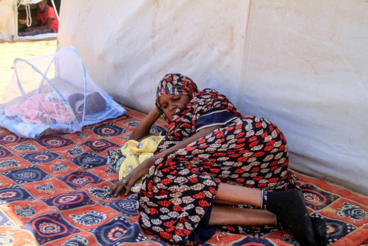 Une femme qui a fui El-Facher, ville du Darfour (ouest) prise par les paramilitaires, se repose dans un camp pour déplacés soudanais à al-Dabbah, ville du nord du Soudan sous contrôle de l'armée le 13 novembre 2025 ( AFP / Ebrahim Hamid )