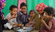 Saeedah Mohammed, une déplacée yéménite, nourrit ses petits-enfants avec des feuilles bouillies dans leur tente du camp d'Al-Manij, près de Taëz, dans le sud ouest du Yémen, le 21 mai 2026 ( AFP / Ahmed al-Basha )