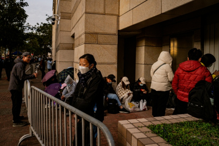 Des personnes attendent devant le tribunal de West Kowloon pour le verdict dans le procès de Jimmy Lai, le 15 décembre 2025 à Hong Kong ( AFP / Leung Man Hei )