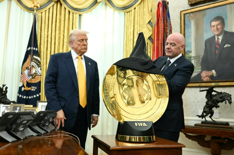 Le patron de la Fédération internationale de football, Gianni Infantino (d), dévoile le trophée de la Coupe du monde des clubs devant le président américain Donald Trump, à la Maison Blanche, le 7 mars 2025 à Washington ( AFP / Jim WATSON )