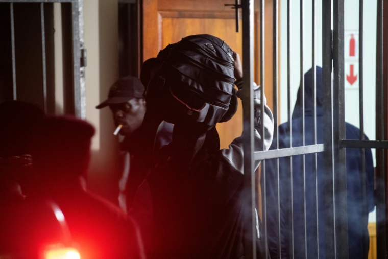 Un étranger transporte ses affaires dans une salle communautaire, où il a trouvé refuge, à Stanford (Afrique du Sud), à environ 120 km du Cap, le 2 juin 2026, après avoir été menacés par des groupes antimigrants ( AFP / RODGER BOSCH )