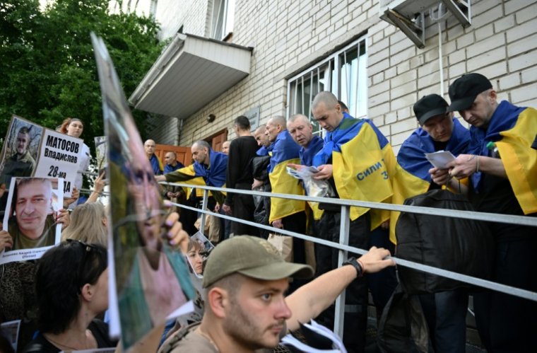 Des prisonniers ukrainiens accueillis par des familles à leur arrivée après un échange de prisonniers dans la région de Tcherniguiv, le 23 mai 2025 ( AFP / Genya SAVILOV )