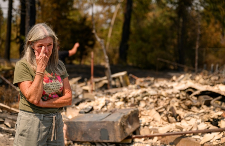 Une femme au milieu des ruines laissées par les flammes à Spokane, dans l'Etat de Washington, le 4 août 2026 ( AFP / Josh Edelson )