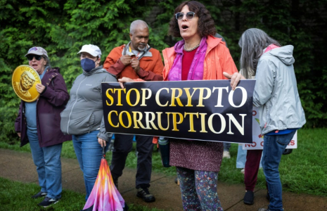 Des manifestants devant le Trump National Golf Course à Sterling, en Virginie, le 22 mai 2025, où le président Donald Trump participe à un dîner privé dans son club pour les 220 plus gros détenteurs de sa cryptomonnaie ( AFP / Jim WATSON )