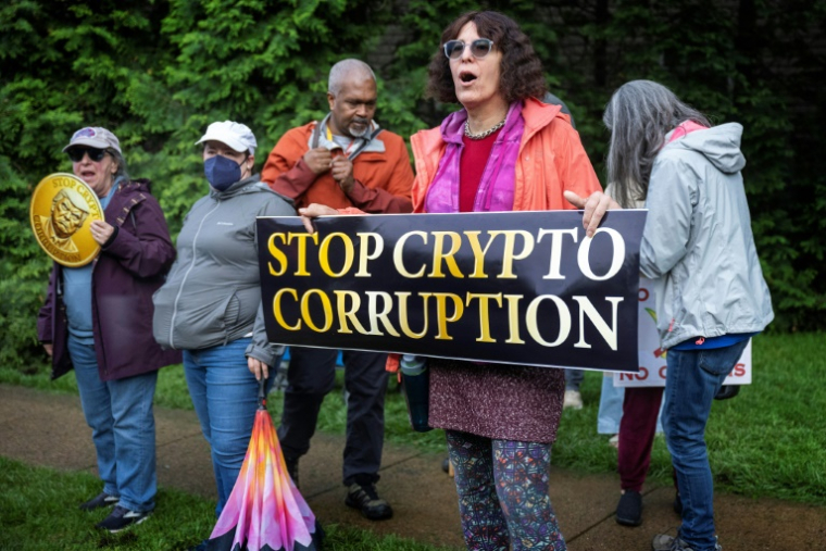 Des manifestants devant le Trump National Golf Course à Sterling, en Virginie, le 22 mai 2025, où le président Donald Trump participe à un dîner privé dans son club pour les 220 plus gros détenteurs de sa cryptomonnaie ( AFP / Jim WATSON )
