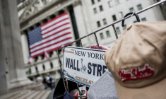 Une plaque portant l'inscription « Wall Street » est visible sur l'étal d'un vendeur ambulant devant la Bourse de New York (NYSE), à New York.