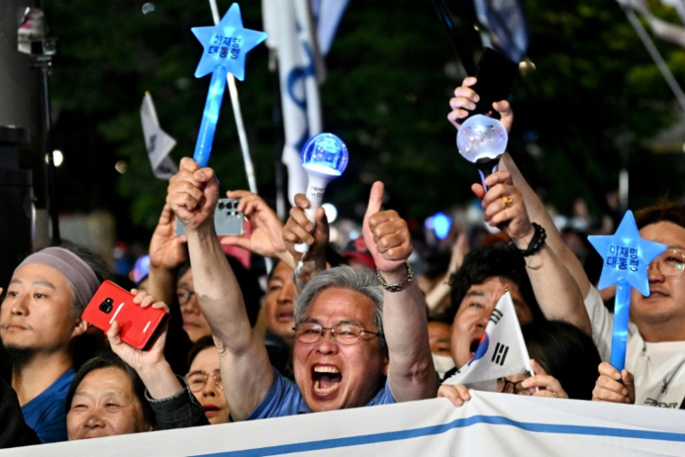 Des partisans du candidat de centre-gauche à la présidentielle sud-coréenne Lee Jae-myung explosent de joie à l'annonce des premiers sondages sortie des urnes, le 3 juin 2025 à Séoul ( AFP / Pedro PARDO )