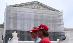 Deux hommes portant des casquettes "Make America Great Again" (MAGA, Rendre sa grandeur à l'Amérique), passent devant la Cour suprême des Etats-Unis, à Washington, le 27 juin 2025 ( AFP / Alex WROBLEWSKI )