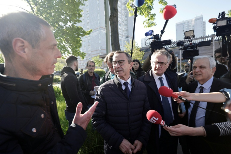 Le candidat LR à la présidentielle Bruno Retailleau (c) parle avec un habitant du quartier Pablo Picasso, accompagné par le député Philippe Juvin (2e d) et le premier vice-président du Sénat Roger Karoutchi (d), le 23 avril 2026 à Nanterre ( AFP / STEPHANE DE SAKUTIN )