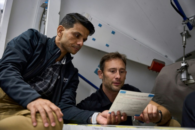 Photo prise le 6 septembre 2024 et diffusée par la société aérospatiale privée Axiom Space montrant les membres de l'équipage assignés à l'Ax-4, Shubhanshu Shukla (g) et le Polonais Slawosz -Wisniewski, examinant une liste de contrôle de procédure pendant leur formation dans la maquette du module ISS Harmony au Johnson Space Center (JSC) de la NASA à Houston, au Texas ( AXIOM SPACE / - )