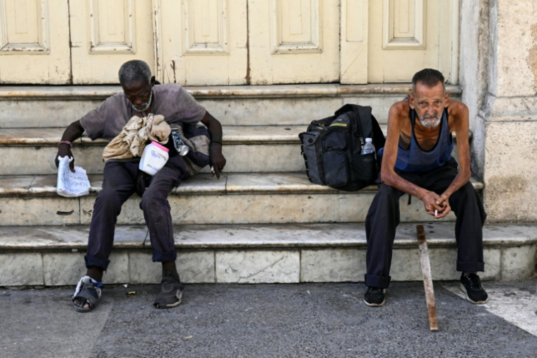 Des sans-abri dans une rue de La Havane, le 21 juillet 2025 à Cuba ( AFP / Yamil LAGE )