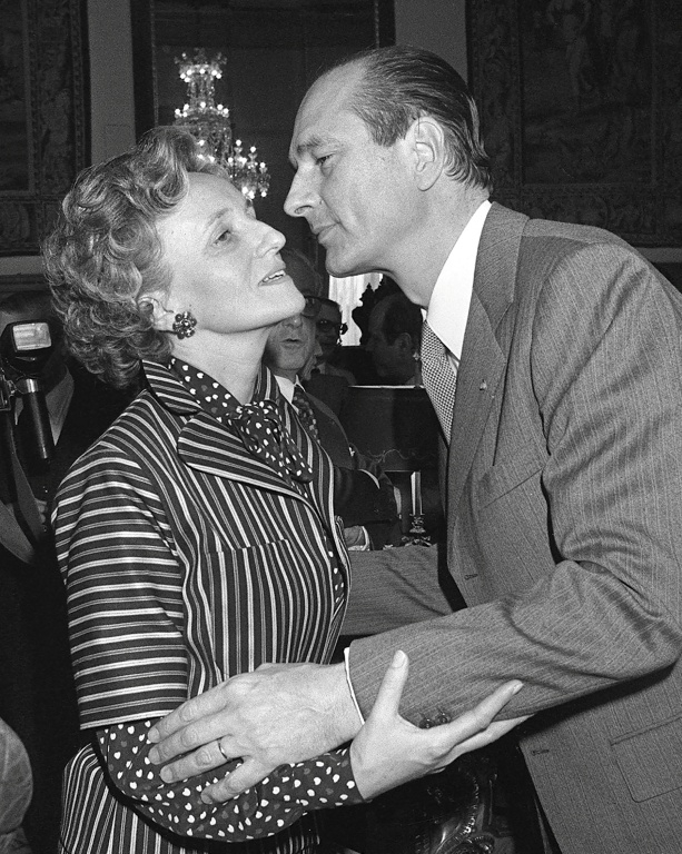 L'ex-président français Jacques Chirac (D) embrasse son épouse Bernadette au soir de son élection comme maire de Paris, le 25 mars 1977  ( AFP / GEORGES BENDRIHEM )
