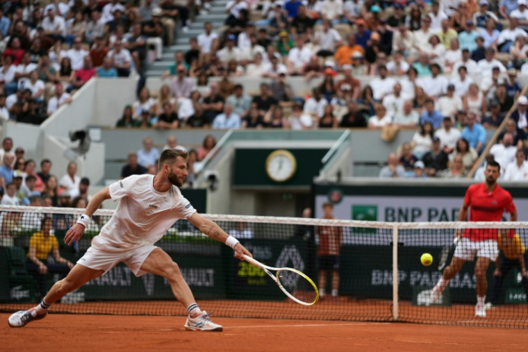 Corentin Moutet et Novak Djokovic à Roland-Garros le 29 mai 2025 ( AFP / Dimitar DILKOFF )