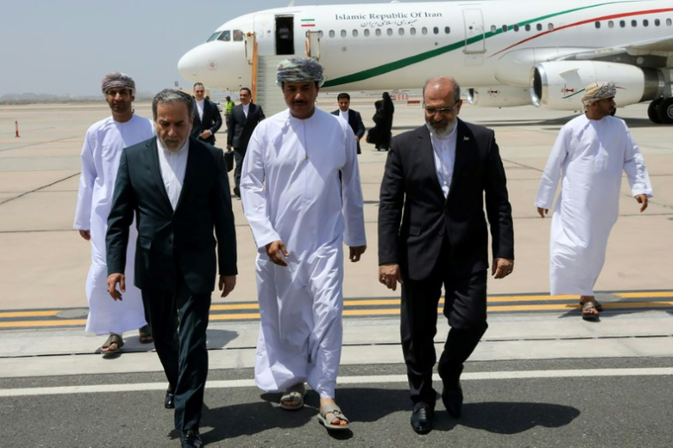 Une photo fournie par le ministère iranien des Affaires étrangères montre le chef de la diplomatie Abbas Araghchi (G), arrivant à Mascate, le 11 mai 2025 ( Iranian Foreign Ministry / - )