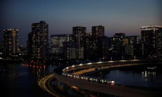 Un train de la ligne Yurikamome circule avec la silhouette urbaine en arrière-plan, à Tokyo