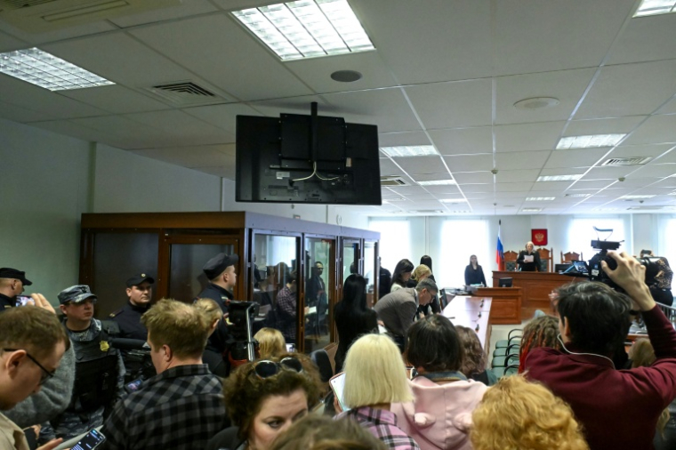Des militants russes antiguerre du mouvement de jeunesse pro-démocratie Vesna attendent dans le box des accusés l'annonce de leur verdict au tribunal de Saint-Pétersbourg, le 8 avril 2026 ( AFP / Olga MALTSEVA )