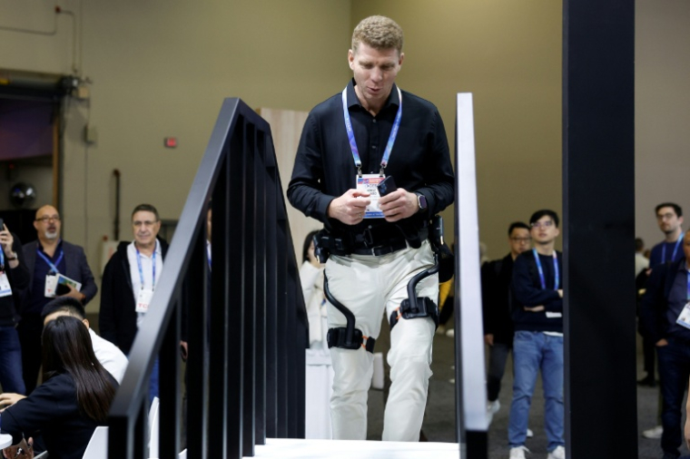 Un visiteur du salon de la technologie grand public CES essaie un exosquelette de Dnsys le 6 janvier 2026 à Las Vegas ( AFP / Caroline Brehman )