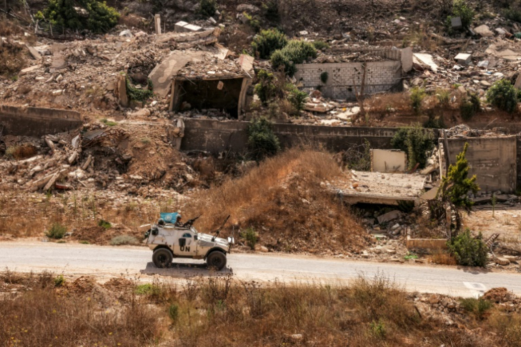 Un véhicule blindé de la Force intérimaire des Nations Unies au Liban (Finul) passe devant des bâtiments détruits le long d'une route dans le village de Kfar Kila, dans le sud du Liban, près de la frontière avec le nord d'Israël, le 27 août 2025 ( AFP / ANWAR AMRO )