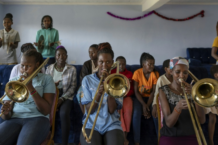 Des adolescentes, issues pour la plupart de la communauté massaï, participent à une formation musicale à la Maison de l'espoir, un centre qui héberge et éduque des mineures sauvées des mutilations génitales féminines (MGF) et des mariages précoces, à Narok, au Kenya, le 1er décembre 2025 ( AFP / Tony KARUMBA )