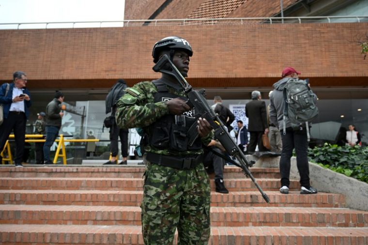 Un membre de la police militaire monte la garde devant la clinique Santa Fe où le sénateur Miguel Uribe est hospitalisé après avoir été blessé par balle lors d'un meeting politique, le 10 juin 2025 à Bogota, en Colombie ( AFP / Raul ARBOLEDA )