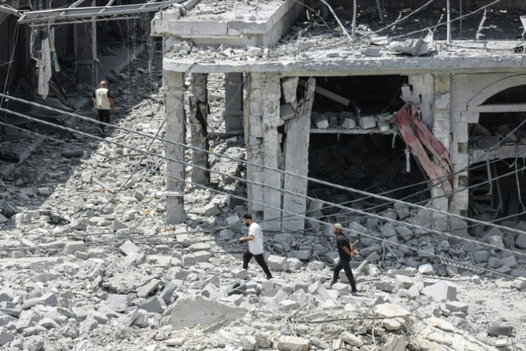Des habitants déplacés, de retour à Nabatiyé, se fraient un chemin au milieu des décombres d'un immeuble détruit, le 15 juin 2026 dans le sud du Liban ( AFP / MAHMOUD ZAYYAT )