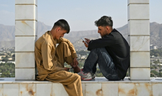 Des jeunes Afghans consultent leurs smartphones, sur la colline de Wazir Akbar Khan, à Kaboul, le 10 août 2026 ( AFP / Wakil KOHSAR )