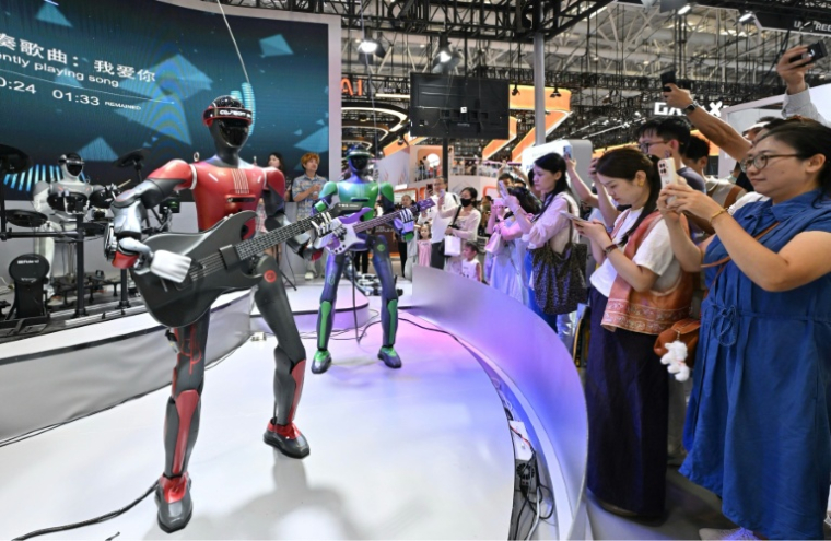 Des robots humanoïdes Casbot jouent de la guitare lors du salon mondial des robots à Pékin, le 19 août 2026 ( AFP / ADEK BERRY )