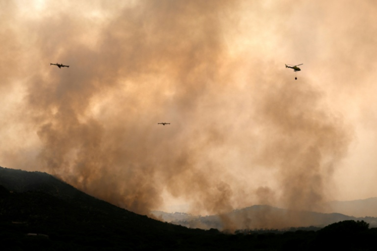 Des avions de lutte contre les incendies larguent de l'eau sur un feu de forêt près du village de Cebreros, dans la province d'Ávila, en Espagne, le 27 juillet 2026 ( AFP / MIGUEL RIOPA )