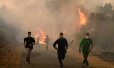 Des personnes fuient les flammes à Larouco, dans le nord-ouest de l'Espagne, le 13 août 2025 ( AFP / MIGUEL RIOPA )