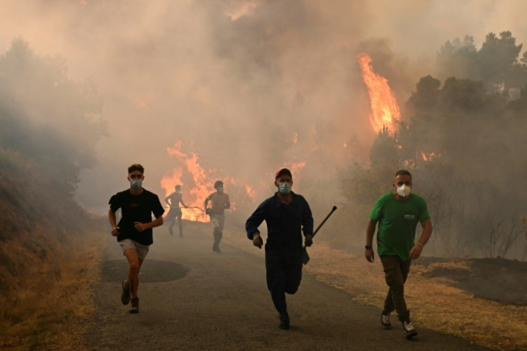 Des personnes fuient les flammes à Larouco, dans le nord-ouest de l'Espagne, le 13 août 2025 ( AFP / MIGUEL RIOPA )
