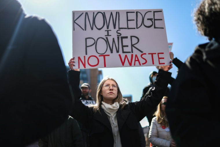 Une manifestante brandit une pancarte "le savoir est un pouvoir, pas du gâchis", lors d'une manifestation contre les attaques à l'égard de la science, à New York, le 7 mars 2025 ( AFP / CHARLY TRIBALLEAU )