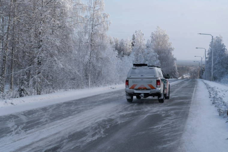 Un véhicule des garde-frontières finlandais roule sur la route déserte vers la frontière russe ( AFP / Alessandro RAMPAZZO )