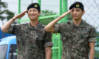 Les membres du boys band K-pop BTS RM (g) et V font un salut militaire dans un centre sportif en plein air à Chuncheon, en Corée du Sud, après avoir été libérés de leur service obligatoire le 10 juin 2025 ( AFP / Shin Yong-ju )