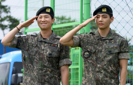 Les membres du boys band K-pop BTS RM (g) et V font un salut militaire dans un centre sportif en plein air à Chuncheon, en Corée du Sud, après avoir été libérés de leur service obligatoire le 10 juin 2025 ( AFP / Shin Yong-ju )