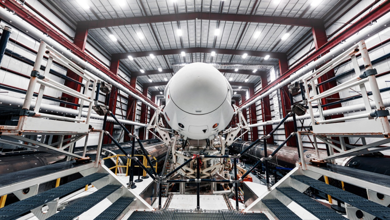 La capsule Crew Dragon de SpaceX, perchée au sommet de la fusée Falcon 9, à l’intérieur du hangar, juste avant son transfert vers la rampe de lancement. (Crédits: Adobe Stock)