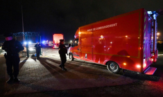 Des policiers près d'un véhicule des sapeurs-pompiers à Calais après le naufrage d'un bateau transportant des migrants qui a fait 31 morts, le 24 novembre 2021 ( AFP / FRANCOIS LO PRESTI )