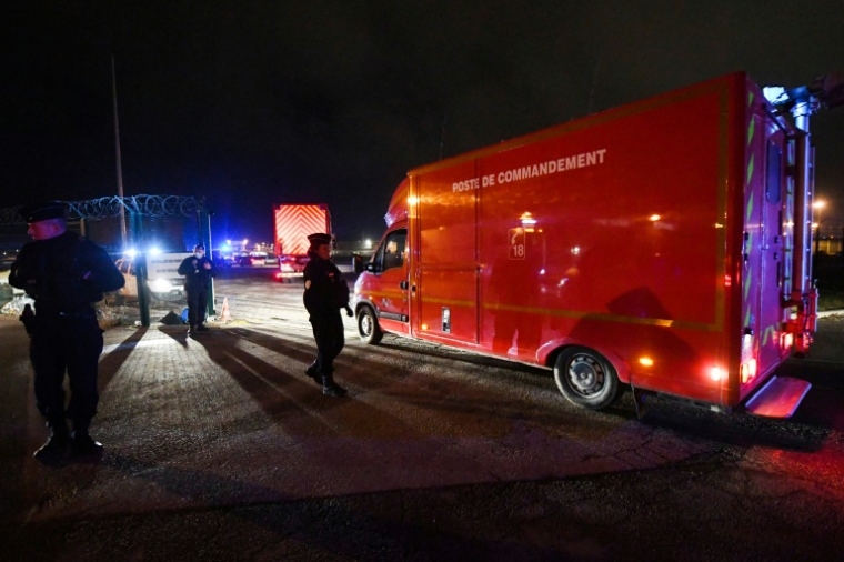 Des policiers près d'un véhicule des sapeurs-pompiers à Calais après le naufrage d'un bateau transportant des migrants qui a fait 31 morts, le 24 novembre 2021 ( AFP / FRANCOIS LO PRESTI )