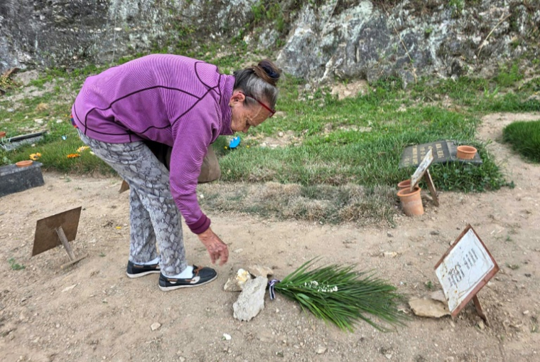 Carmen Navas dépose des fleurs sur la tombe de son fils, le prisonnier politique Victor Quero Navas, dans un cimetière de Caracas, le 7 mai 2026 ( AFP / Maryorin Mendez )