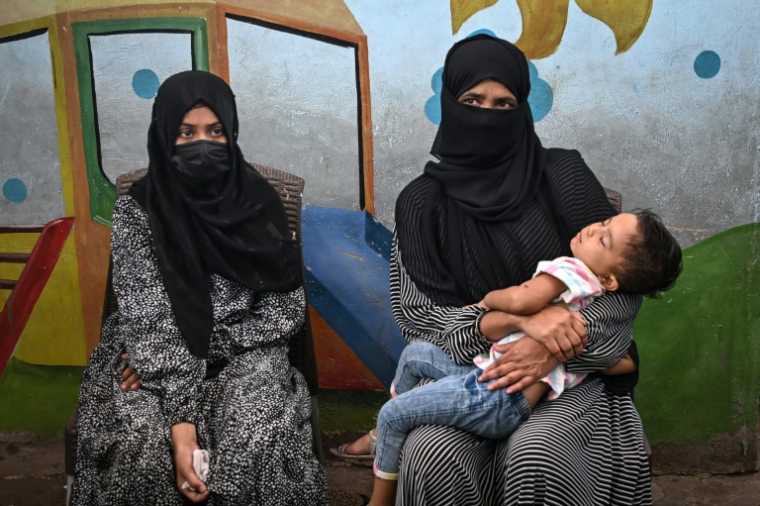 Amina (g), aide ménagère, et sa mère, lors d'une interview avec l'AFP à Karachi, le 31 juillet 2025 au Pakistan ( AFP / Rizwan TABASSUM )