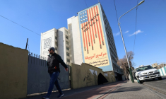 Un Iranien passe devant une immense fresque anti-américaine peinte sur un bâtiment dans la capitale iranienne, Téhéran, le 31 janvier 2026 ( AFP / Atta KENARE )