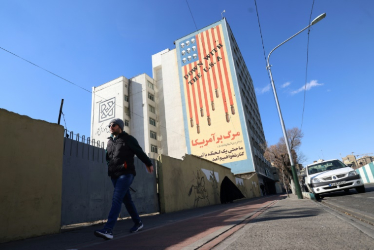 Un Iranien passe devant une immense fresque anti-américaine peinte sur un bâtiment dans la capitale iranienne, Téhéran, le 31 janvier 2026 ( AFP / Atta KENARE )