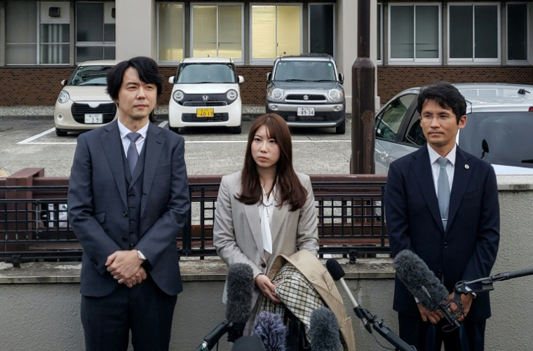 Riho Fukuyama (au centre) et son mari Yoshiki Fukuyama (à gauche) s'adressent aux médias avec leur avocat (à droite) devant le tribunal du district de Toyama, dans la ville de Toyama, le 21 octobre 2025 ( AFP / Natsuko FUKUE )