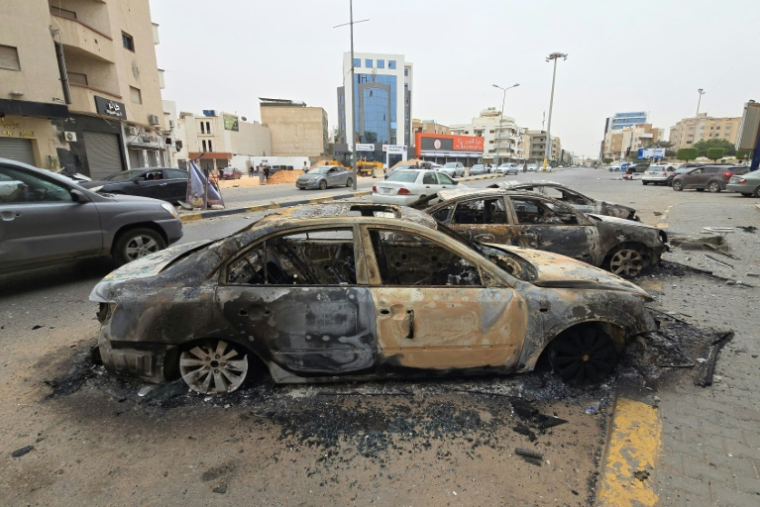 Des véhicules brûlés dans une rue de Tripoli, le 14 mai 2025 en Libye ( AFP / Mahmud Turkia )