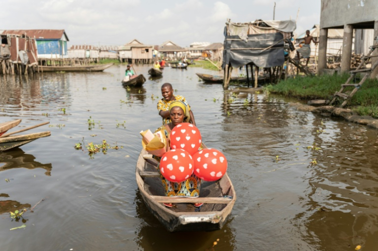 Un couple en pirogue quittent la Place des Amoureux après avoir fêté la Saint-Valentin dans la ville lacustre de Ganvié, le 10 février 2026 au Bénin ( AFP / Yanick Folly )