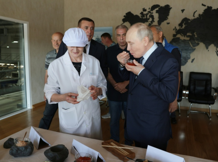 Photo de l'agence russe Sputnik montrant Vladimir Poutine goûtant du caviar au cours d'une visite sur les îles Kouriles, disputées avec le Japon, le 13 aout 2026 ( POOL / Gavriil Grigorov )