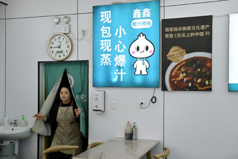 Yin Chunlan, employée dans un restaurant de la ville chinoise de Baoding, dans le district de Xushui à une centaine de kilomètres de Pékin, où les autorités ont ordonné  de remplacer les poêles à charbon par des systèmes électriques ou au gaz, le 7 janvier 2026 ( AFP / Adek BERRY )