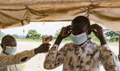 Un agent de santé frontalier contrôle la température d'un voyageur à l'aide d'un thermomètre infrarouge, le 18 mai 2026 à Bundibugyo, en Ouganda ( AFP / Badru Katumba )