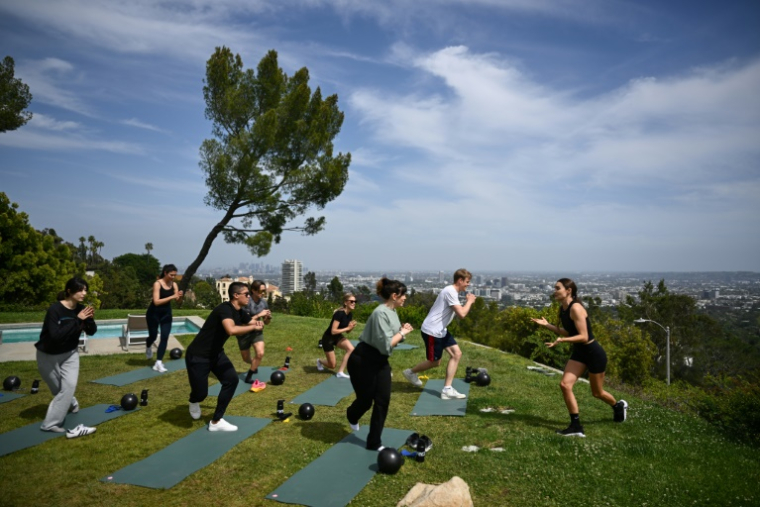 Kirsty Godso, coach de stars, donne un cours de sport à des journalistes pour montrer la nouvelle offre d'"expériences" de la plateforme Airbnb, à Los Angeles le 12 mai 2025 ( AFP / Patrick T. Fallon )