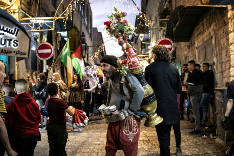Un homme vend du café sur la place de la Mangeoire lors d'une cérémonie d'illumination du sapin de Noël à Bethléem, en Cisjordanie occupée par Israël, le 6 décembre 2025 ( AFP / JOHN WESSELS )